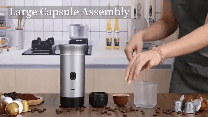 Portable espresso machine being assembled on a kitchen counter with coffee capsules nearby