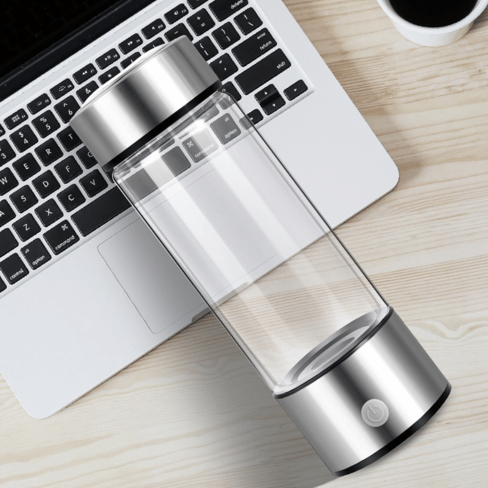 Hydrogen water bottle on desk next to laptop, showing compact and portable design