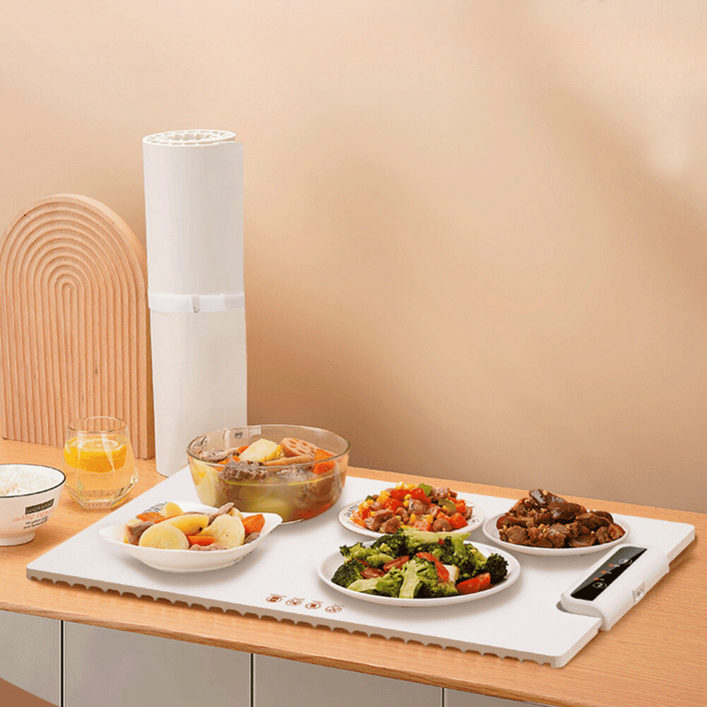 Foldable food warmer in use with multiple dishes, ideal for keeping meals warm on countertops.